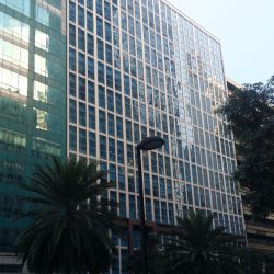 The 6780 has a cube-like shape with a facade of concrete or steel that holds panels of blue-green glass windows.