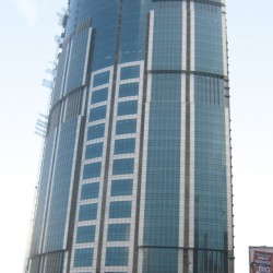 One Corporate Center has a facade of various sizes of blue glass panels and a roof that spirals upward. This photograph was taken from the open park under the flyover along Meralco Ave., north of Julia Vargas Ave.
