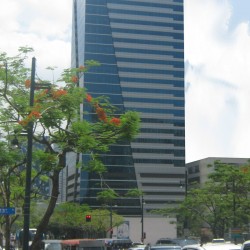 On Global Place is a cuboid building with a facade divided into two sections by a diagonal border: one with alternating horizontal bands of glass and concrete and the other made of entirely glass panels. This is the view from the corner of 5th Ave. and 23rd St.