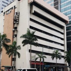 Padilla Building is a low-rise structure with a simple blocky appearance. Its facade is mainly that of a light gray concrete with narrow horizontal strips of recess covered by glass windows. The top of the building has an orange concrete protrusion. There is also an orange vertical concrete cover on the side.