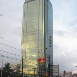 Blocky and glass-clad high-rise PET Plans Tower against a cloudy sky.