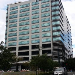 Total Corporate Center has a cuboid structure and concrete exterior with open windows on the lower floors and glass panels on the upper floors.