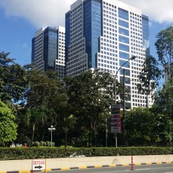 The Tektite Towers is a building made of two cuboid towers with a facade of white concrete and blue glass panels. The picture was taken from the sidewalk along San Miguel Avenue between Julia Vargas Ave. and the main gate of the San Miguel compound.
