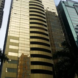 Raffles has a gold/bronze-colored exterior covered with glasses and has a balcony in the middle of each floor.
