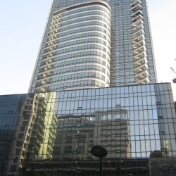 Smart Tower has a facade of glass panels in its entirety. The structure can be divided into the podium and the tower. The cuboid podium covers the entire land area, while the tower has smaller floor areas and is recessed from the frontage. This is Smart Tower seen with the camera slanted upward while standing on the sidewalk on the opposite side of Ayala Avenue between Rufino Pacific Tower and Makati Sky Plaza.