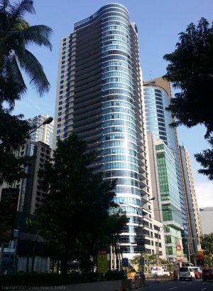 The Malayan plaza has a facade made mostly of blue glass windows. It's shape is like a tall block with an overlapping cylinder in one corner. The four lower floors has wider floor area than the upper floors.