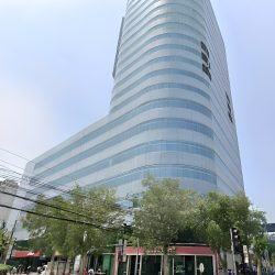 Times Plaza has an exterior of alternating horizontal bands of gray concrete and glass panels. It has lower podium levels with more extensive floor areas and higher tower levels with smaller floor areas. This is Times Plaza, as seen from the island dividing Taft Avenue under LRT railways near its intersection with UN Avenue.