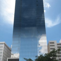 Tower 6789 is covered with glass panels and has an almost rectangular prism shape if not for the protrusion near the top. Shown here is the backside of Tower 6789, as seen from Valero St.