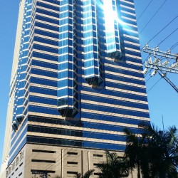 Union Bank Plaza is a bottle-like building with alternating bands of blue glass panels and beige concrete. This is the Union Bank Plaza, viewed from along Sapphire Road in front of Parc Chateau.