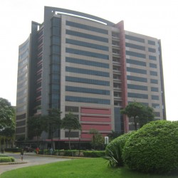 Vertex One's cube-shaped structure showcases predominantly black, red, and gray colors with dark glass window panels. This picture is as seen from the roundabout in front of the gate of Celadon Park.